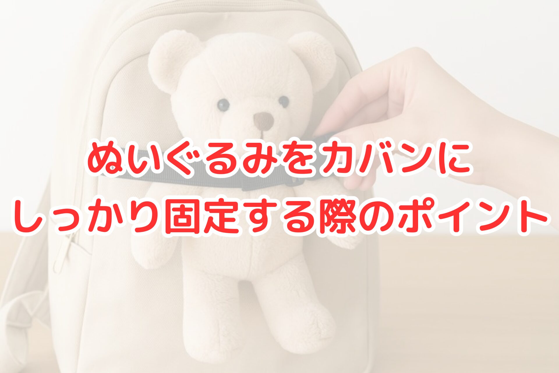 ベージュのリュックの前面に、黒いストラップでぬいぐるみのクマをしっかり固定している様子。手がバックルを留めているところが写り、明るく清潔感のある雰囲気の写真。